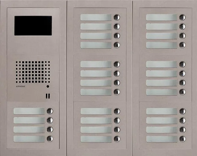 Trippelt panel med skjerm, høyttaler, tolv navnskilt og tolv knapper.
