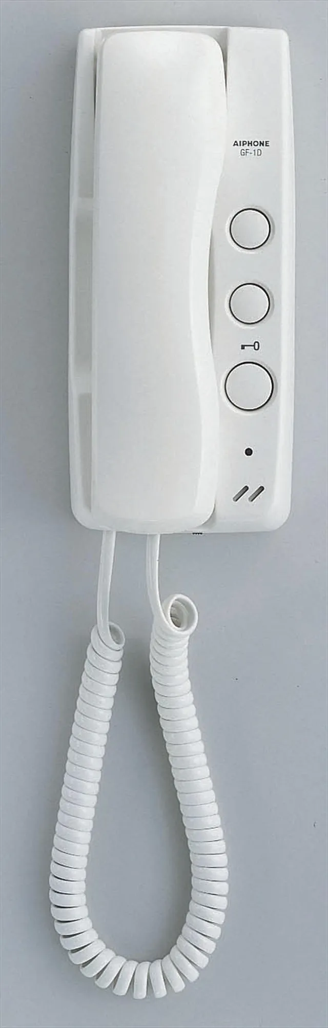Hvit dørtelefon Aiphone GF-1D med tre knapper og spiralrør, montert på vegg.